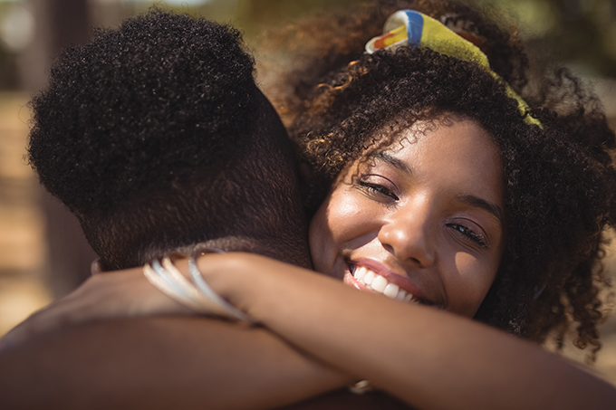 Couple hugging woman smiling