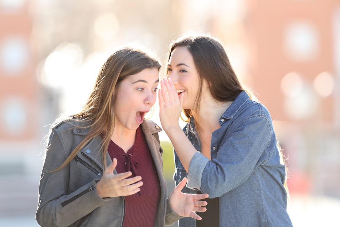 A woman whispering to another that she can win the lottery using the secret