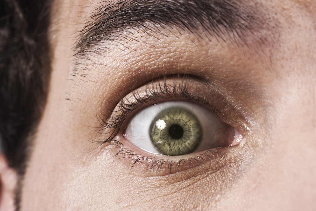 A close-up of a man's eye, shocked after discovering the importance of staying safe after winning the lottery